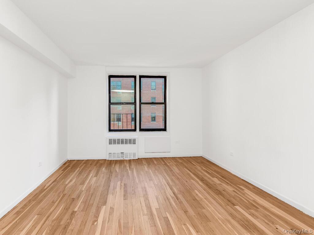 2165 Matthews Avenue, Unit 4A Bronx, NY 10462 - Photo 11 of 23 an empty room with wooden floor and windows
