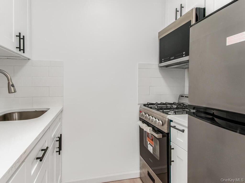 2165 Matthews Avenue, Unit 4A Bronx, NY 10462 - Photo 3 of 23 a kitchen with a stove and a microwave