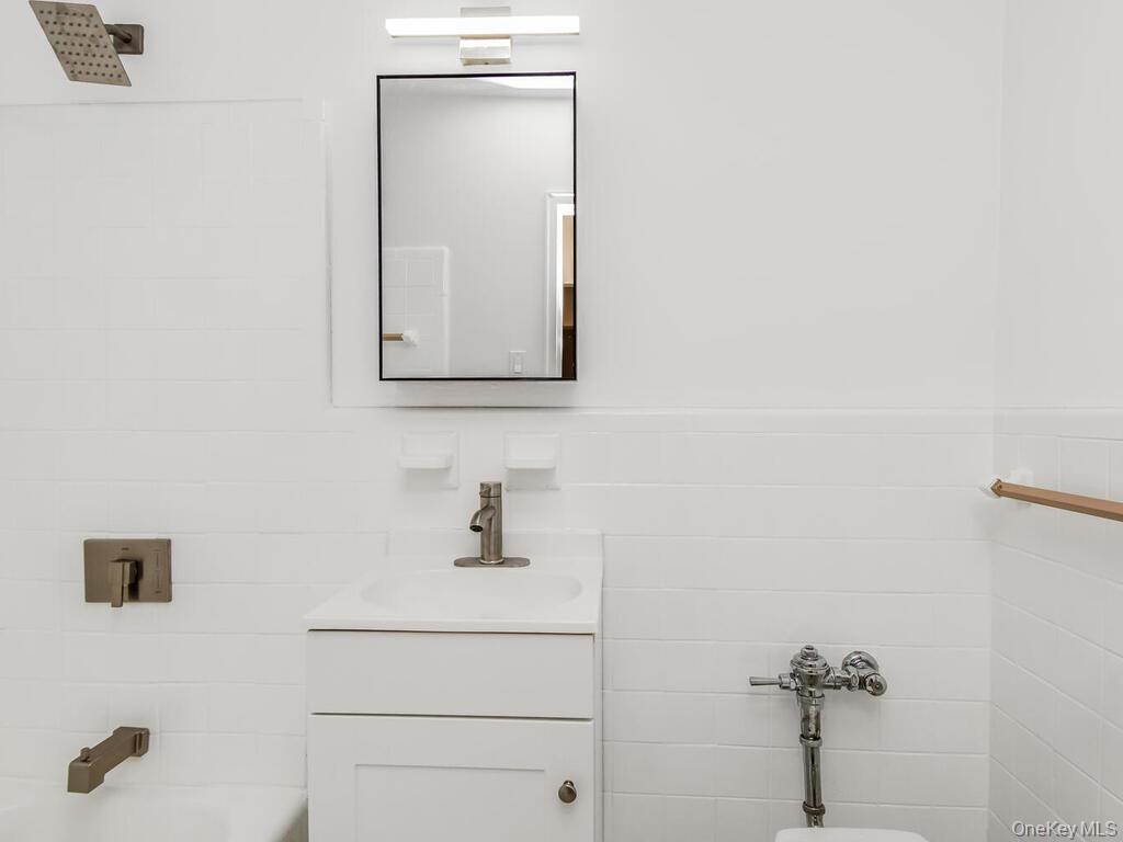 2165 Matthews Avenue, Unit 4A Bronx, NY 10462 - Photo 5 of 23 a bathroom with a sink a mirror and vanity