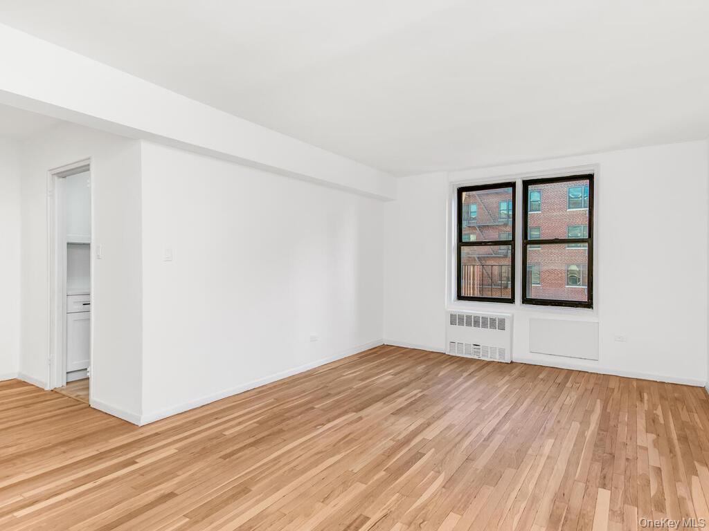 2165 Matthews Avenue, Unit 4A Bronx, NY 10462 - Photo 10 of 23 an empty room with wooden floor and windows