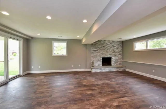 an empty room with windows and fireplace