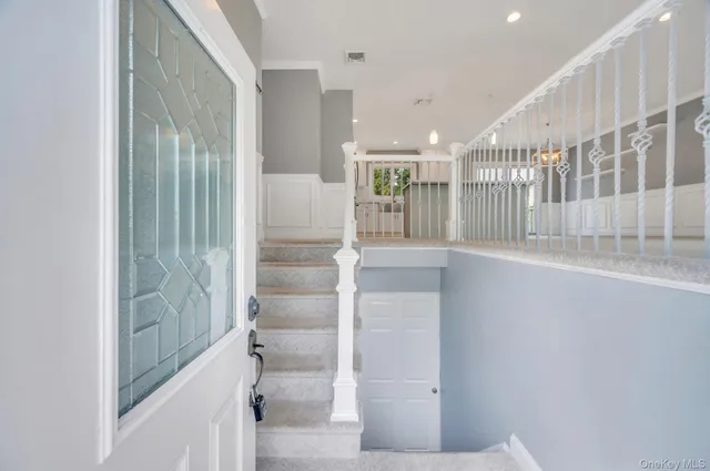 a view of a hallway with wooden floor and a bathroom