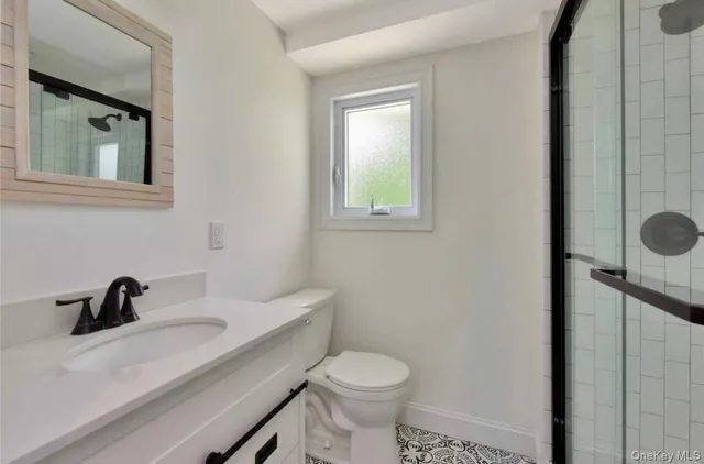 a bathroom with a sink a toilet and a mirror