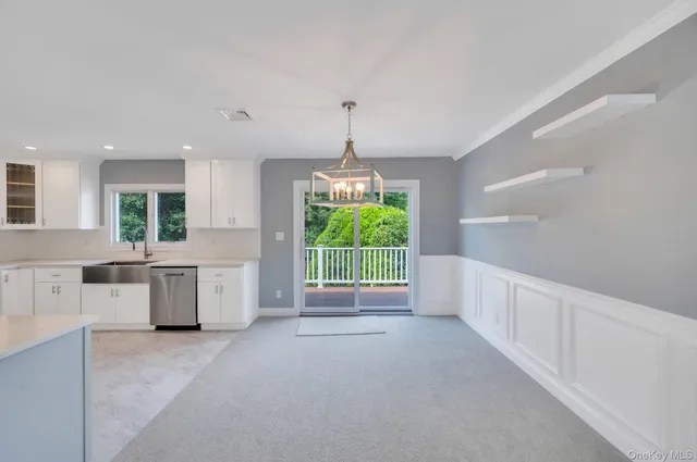 a open kitchen with white cabinets and window
