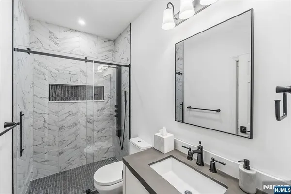 a bathroom with a sink a toilet and shower