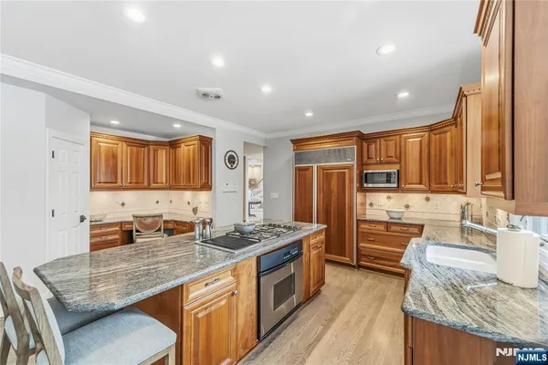 a kitchen with granite countertop lots of counter top space a sink stainless steel appliances and cabinets