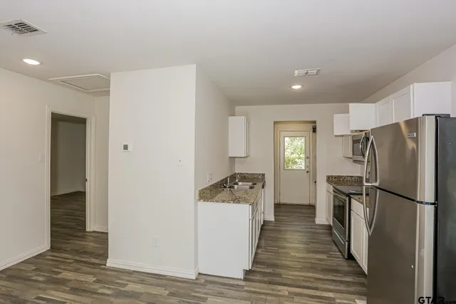 a kitchen with a refrigerator and a sink
