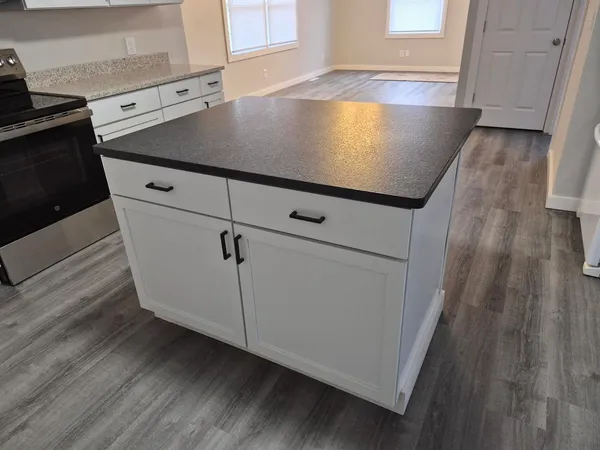 a kitchen with granite countertop white cabinets white stainless steel appliances and sink