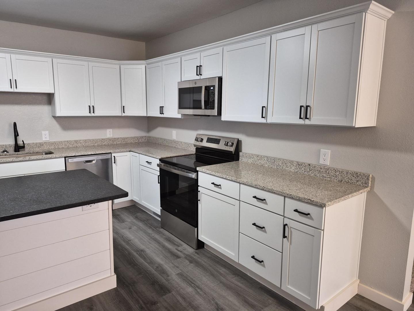 101 North 6th Avenue New Windsor, IL 61465 - Photo 14 of 33 a kitchen with granite countertop white cabinets white stainless steel appliances and sink