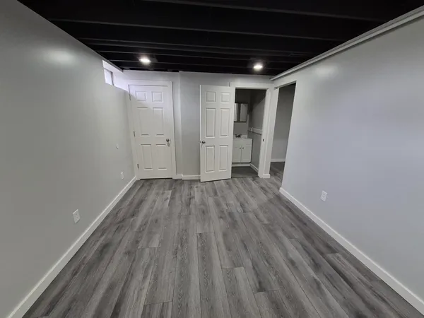 an empty room with a ceiling fan and windows