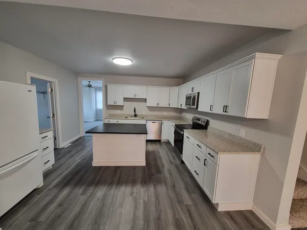 a kitchen with a sink a microwave and cabinets