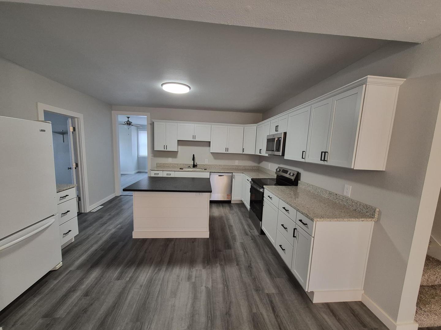 101 North 6th Avenue New Windsor, IL 61465 - Photo 10 of 33 a kitchen with granite countertop white cabinets and white appliances