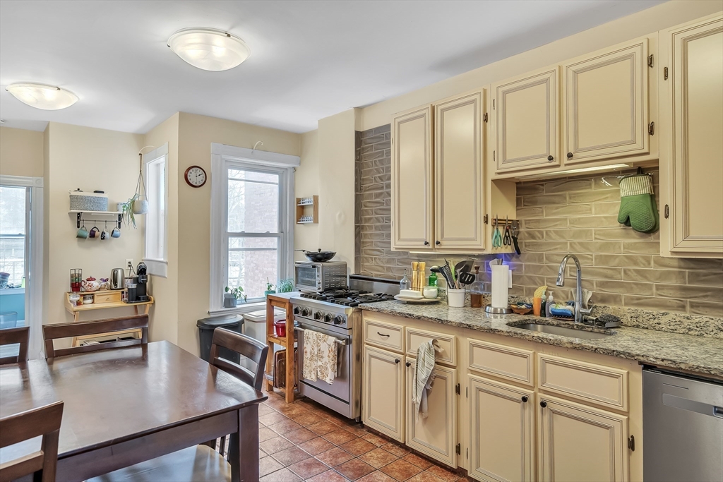 1891 Beacon Street, Unit 2 Brookline, MA 02445 - Photo 12 of 31 a kitchen with stainless steel appliances granite countertop a sink dishwasher stove and cabinets with wooden floor