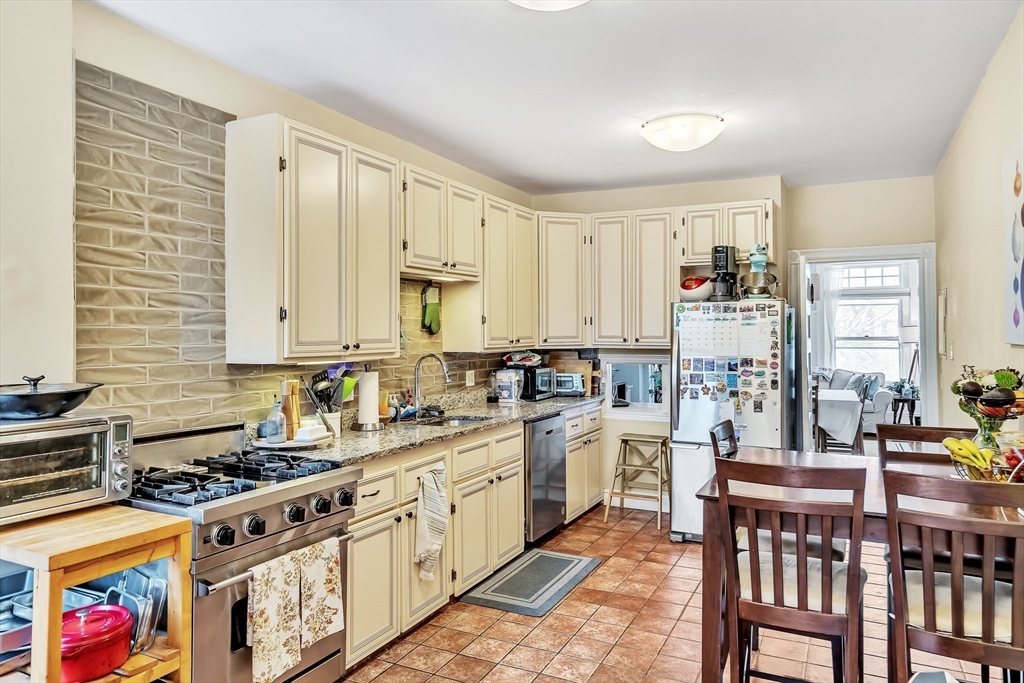 1891 Beacon Street, Unit 2 Brookline, MA 02445 - Photo 14 of 31 a kitchen with stainless steel appliances a stove a sink dishwasher and cabinets with wooden floor