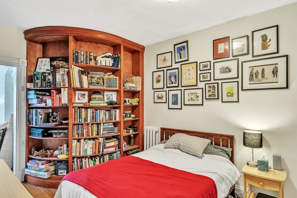 1891 Beacon Street, Unit 2 Brookline, MA 02445 - Photo 23 of 31 a bedroom with a bed book shelf and a book shelf