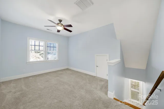 en empty room with ceiling fan and window