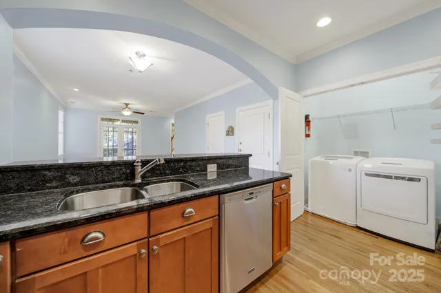 a kitchen with stainless steel appliances granite countertop a sink a stove and a wooden floors