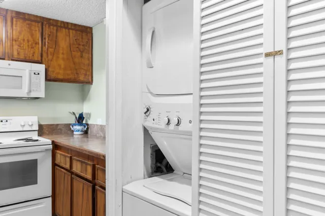 a kitchen with stainless steel appliances a dining table chairs and wooden floor