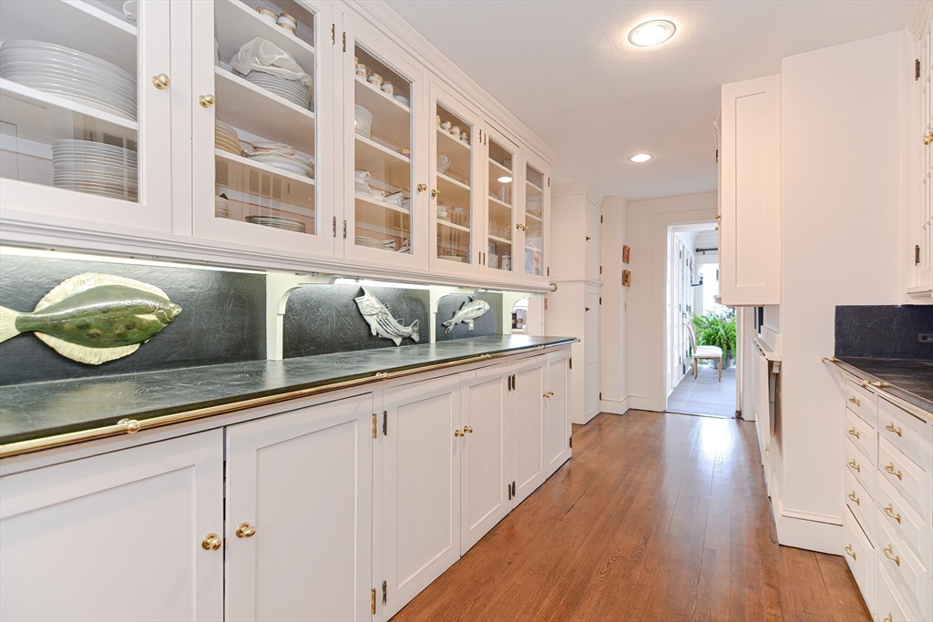 33 Way Road Gloucester, MA 01930 - Photo 18 of 38 a kitchen with granite countertop wooden floors white cabinets and wooden floor