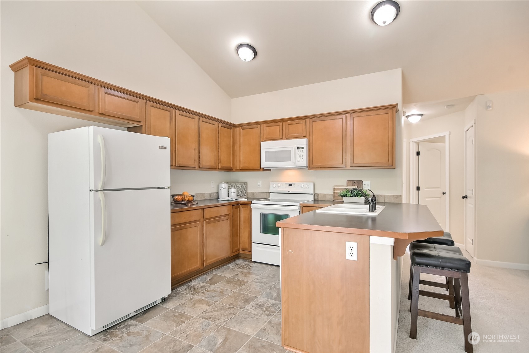 9814 201st Street East Graham, WA 98338 - Photo 9 of 40 a kitchen with a refrigerator a sink and a stove