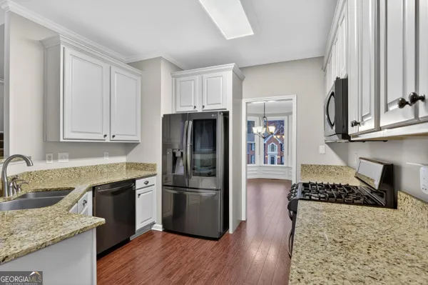 a kitchen with granite countertop a refrigerator and a sink