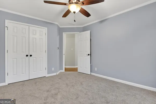 a view of an empty room and chandelier fan