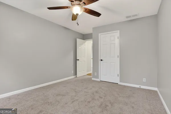 an empty room with chandelier fan