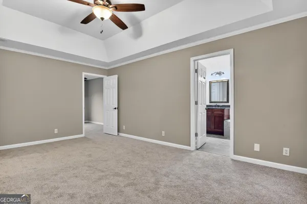 a view of an empty room and a ceiling fan