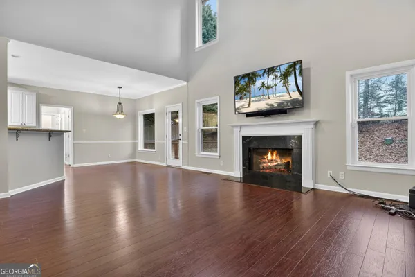 a view of a livingroom with wooden floor and a fireplace