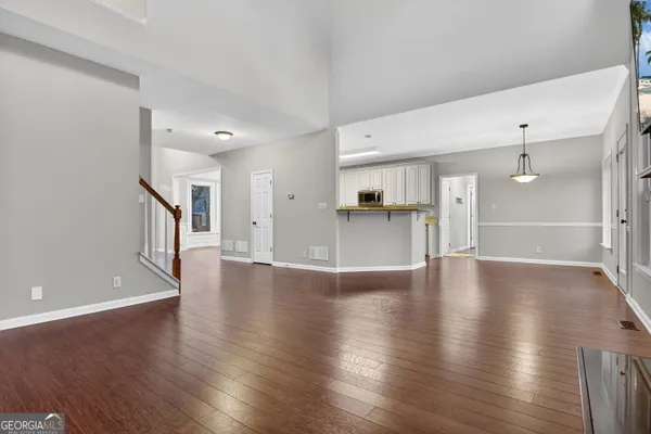 a view of a kitchen with a fridge and wooden floor