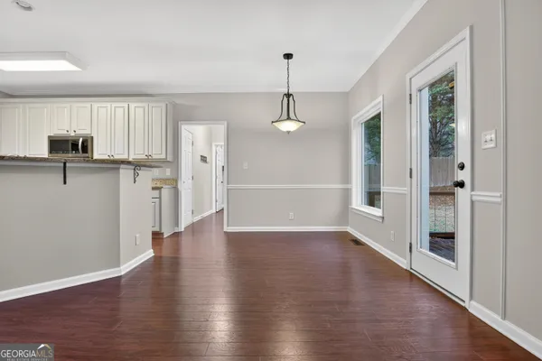 a view of a kitchen with a refrigerator wooden floor and a window