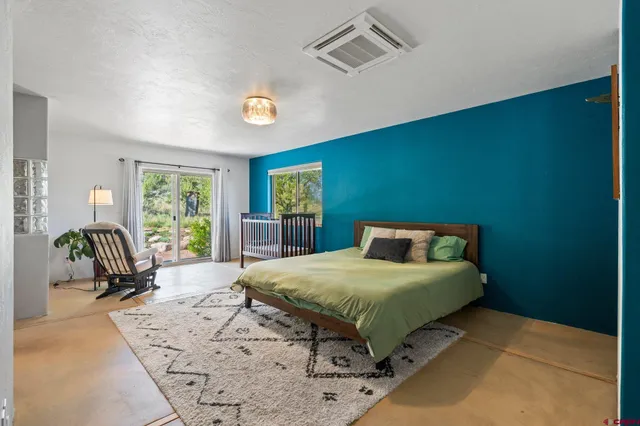 a bedroom with a bed and a large window