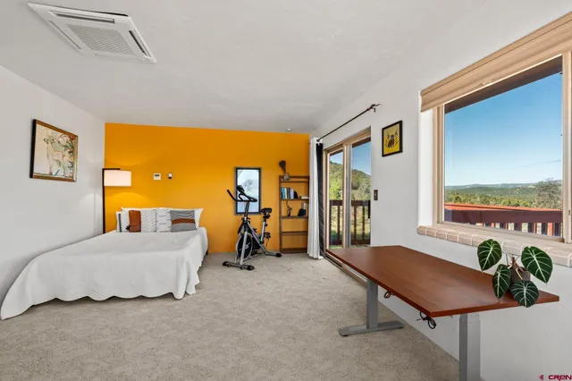 a view of a workspace with furniture and a window