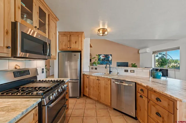 a kitchen with granite countertop a sink stainless steel appliances and cabinets