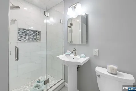 a bathroom with a sink a toilet and shower