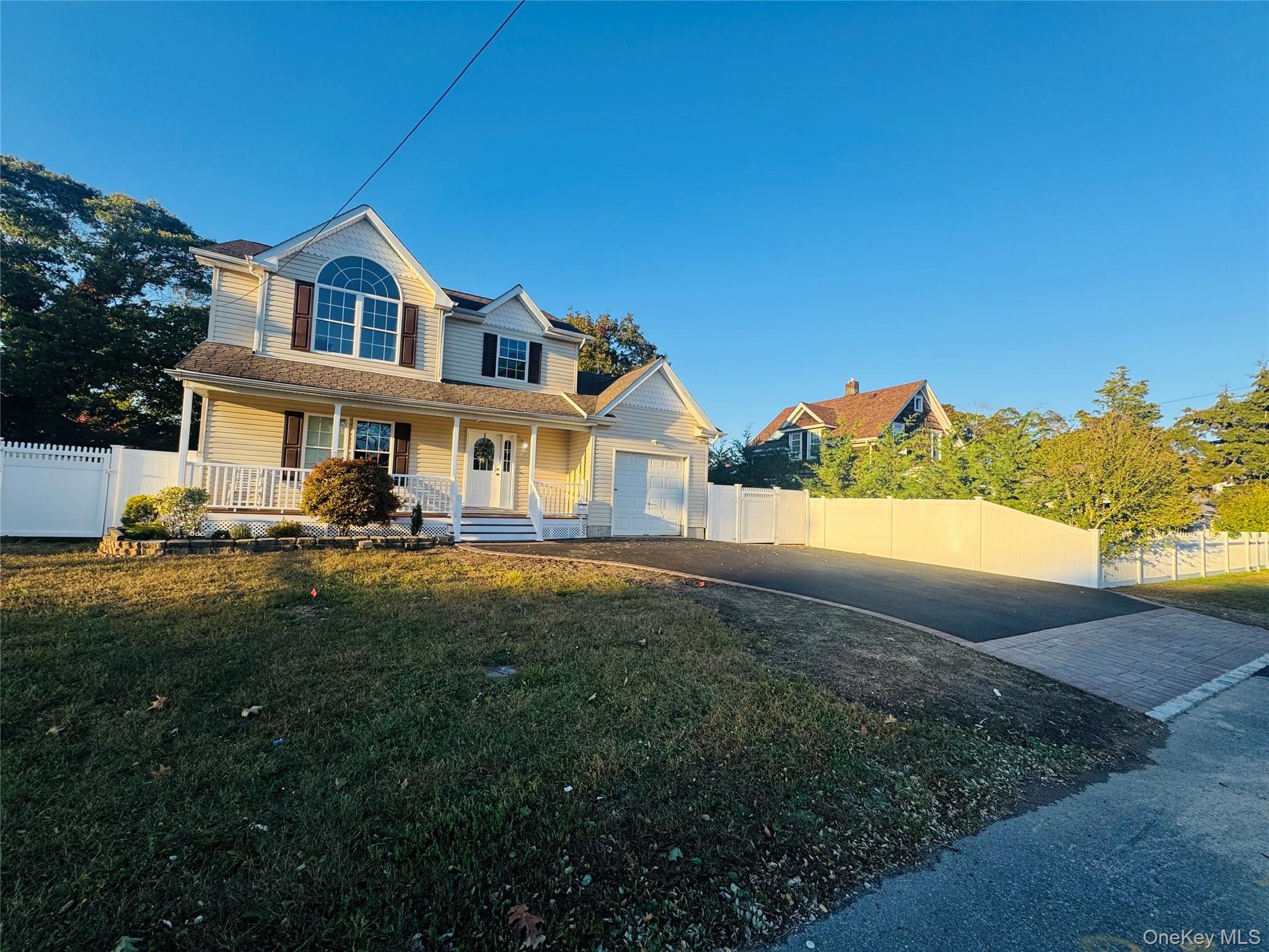 View of front of home featuring a porch, driveway, and a garage