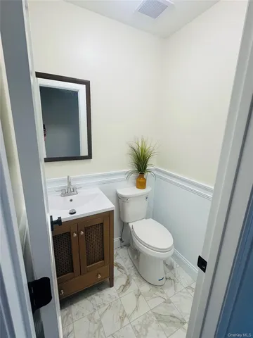 a bathroom with a toilet sink and mirror