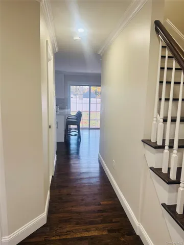 a view of a hallway with wooden floor and staircase