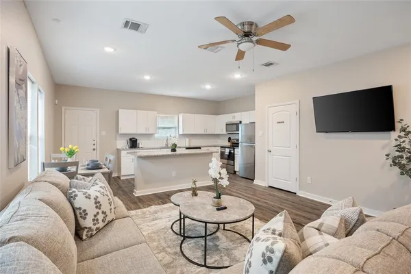 a living room with furniture and a flat screen tv with wooden floor
