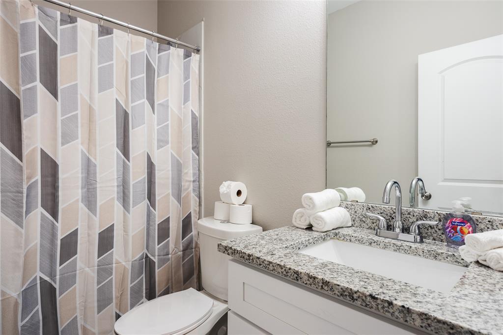 5004 Colonial Avenue Dallas, TX 75215 - Photo 12 of 20 a bathroom with a granite countertop sink and a mirror