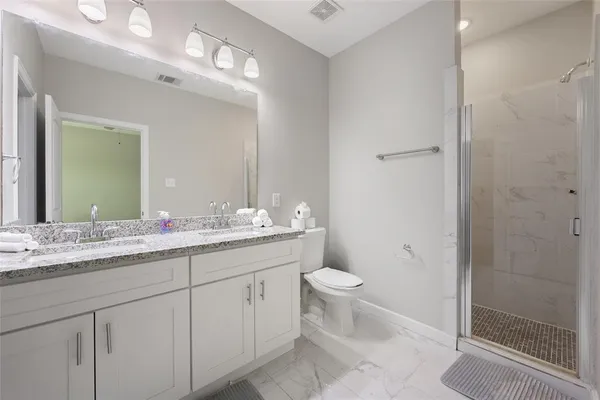 a bathroom with a granite countertop sink toilet and shower