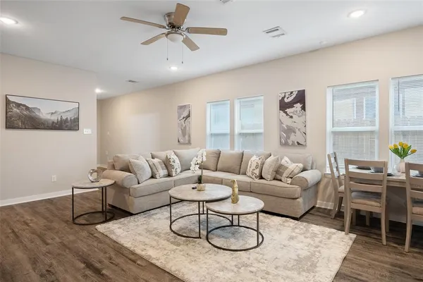 a living room with furniture and a wooden floor