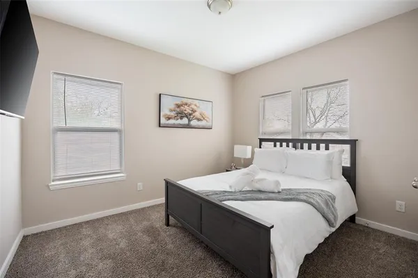 a spacious bedroom with a bed and wall painting