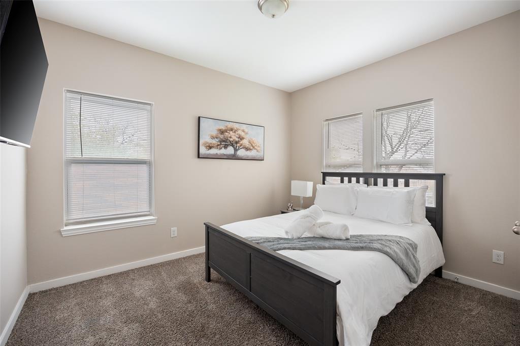 5004 Colonial Avenue Dallas, TX 75215 - Photo 10 of 20 a spacious bedroom with a bed and wall painting