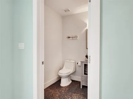 a white toilet sitting next to a white wall