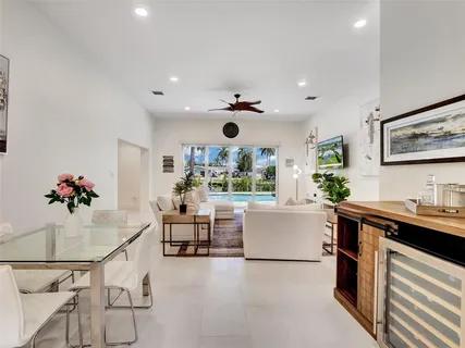 a very nice looking open dining room with kitchen island stainless steel appliances a table and chairs in it