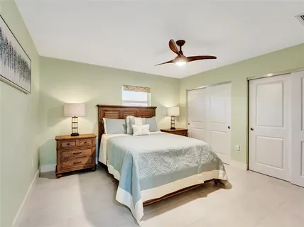 a bedroom with a bed and a ceiling fan