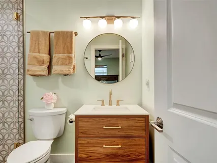 a bathroom with a sink mirror and toilet