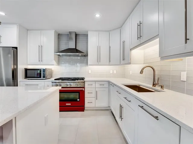 a kitchen with stainless steel appliances granite countertop a stove sink and cabinets