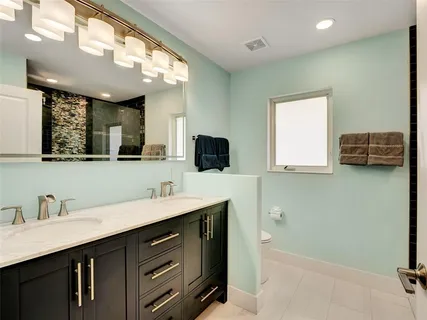 a bathroom with a double vanity sink a mirror and a bathtub
